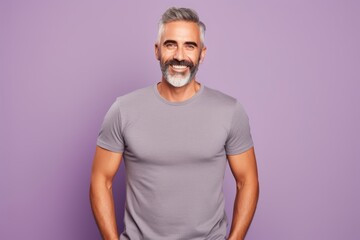 Wall Mural - Handsome middle-aged man in grey t-shirt on violet background