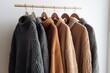 © Rarity Asset Club - Assorted sweaters and jackets on wooden hangers against a dark background.