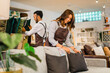 © Odua Images - attractive shopkeeper woman arranges sofa cushions with her friend after opening a furniture store