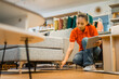 © Odua Images - female shop clerk uses a tablet checking the condition of sofa legs in a furniture store