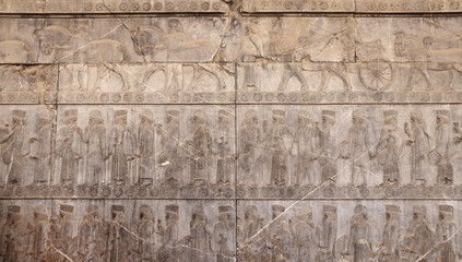 Sticker - Ancient wall with bas-relief with assyrian warriors with spears,  horses, chariots, Persepolis, Iran