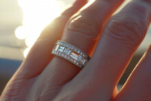 Finger wearing a luxury baguette diamond band engagement ring