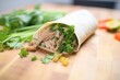 fresh cilantro topping a steaming pulled pork burrito