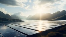  A Group Of Solar Panels Sitting On Top Of A Lush Green Hillside Next To A Lake With Mountains In The Background.