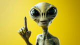 funny portrait of a grey alien pointing up on yellow copy space background