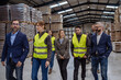 © Halfpoint - Full team of warehouse employees standing in warehouse. Team of workers, managers, female director in modern industrial factory, heavy industry, manufactrury.