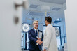 © Halfpoint - Pharmaceutical sales representative presenting new medication to doctor in medical building, shaking hands. Through door.