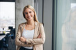 © Westend61 - Smiling businesswoman standing with arms crossed in office