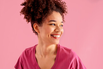 Wall Mural - Attractive smiling female african american with sincere beautiful smile on pink background