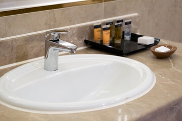 Wall Mural - faucet for water and white sink on marble counter