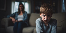 A Portrait Of A Troubled Young Boy With A Look Of Concern, With A Blurred Figure Of A Parent Behind.