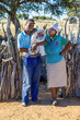 © poco_bw - joyous african parents holding their new born baby, outdoors kitchen in the background village in Botswana