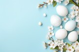 Fototapeta  - White Easter eggs with white flowers on blue background. Top view. Copy space. Happy Easter.