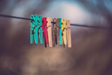 Fototapeta  - Three clothespins placed artistically on the wire. Minimalist image made in the garden
