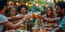 Group Of Multi Ethnic Friends Having Backyard Dinner Party Together - Diverse Young People Sitting At Bar Table Toasting Beer Glasses In Brewery Pub Garden - Happy Hour, Lunch Break And Youth Concept