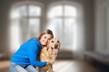 Happy young woman hugging her dog at cozy home.