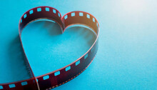 Filmstrip In The Shape Of A Heart On A Blue Background With A Lens Effect