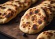 Freshly baked Indian naan flatbread on a wooden board