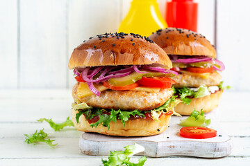 Wall Mural - Chicken hamburger. Sandwich with chicken burger, tomatoes, cheese, pickled cucumber and lettuce. Cheeseburger.
