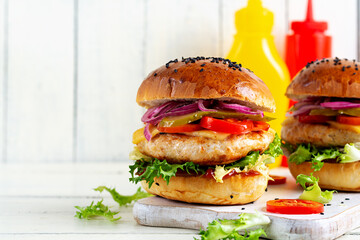 Wall Mural - Chicken hamburger. Sandwich with chicken burger, tomatoes, cheese, pickled cucumber and lettuce. Cheeseburger.