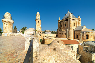 Wall Mural - Dormition Abbey, minaret and belfry under blue sky over the old roofs of Jerusalem, Israel.