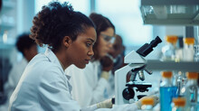 Young Scientists Conducting Research Investigations In A Medical Laboratory, Woman In The Foreground Is Using A Microscope