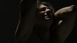 © kinomaster - Portrait of male model in studio on the black background under spotlight. Attractive man silhouette emotional face expression at the camera.