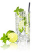 Mojito cocktail in tall crystal glass with drinking straw, lime and mint leaves isolated on white reflective surface.
