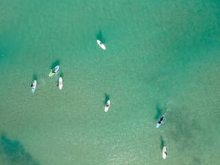 Canvas Print - Aerial view by drone of people practicing Stand Up Paddle or SUP in Mediterranean turquoise clear sea.