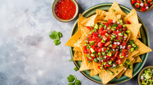 Mexican Nachos Chips With Assorted Sauces – Guacamole, Tomato Salsa, Chili, Lime, And Sour Cream – On A Stone Table. Flat-lay, Top View Banner With Copy Space. Cinco De Mayo Snack.