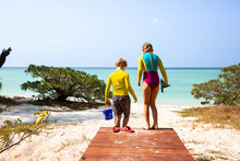 Children Stepping From The Boardwalk To The Sand Of Heron Island Beach