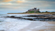 Harkess Rocks below Bamburgh Castle.  Miles of a sandy beach end at Harkess Rocks on the shoreline of the North Sea at Bamburgh in Northumberland, England