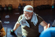 © Davor - Smiling senior man resting after workout with trainer in gym