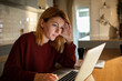 © Vorda Berge - Concerned woman reviewing documents while working from her home kitchen