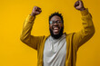 Happy black person , excited young African American male, cheerful black man, screaming in amazement. Surprised face, isolated on yellow background with copy space