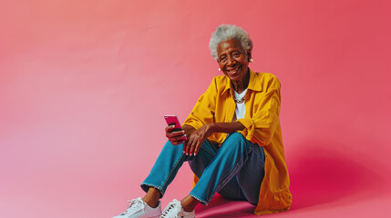 Poster - Joyful elderly woman with white hair smiling while using a smartphone, set against a vibrant pink background.