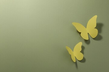 Sticker - Yellow paper butterflies on pale green background, top view. Space for text