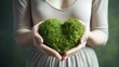 Female hands holding a green heart. The concept of donations and family insurance, World Heart Day. Health day. Gratitude, kindness, volunteers. The theme of ecology.
