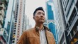 © GoLyaf - Amidst the urban marvels, the Asian man's presence embodies a captivating fusion of tradition and modernity, creating a compelling visual narrative.