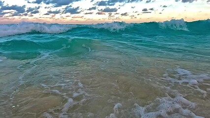 Wall Mural - Marea alta en el mar cariba con agua turquesa y cielo semi nublado en el atardecer, espuma de mar