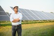 © Serhii - An Indian male engineer working on a field of solar panels. The concept of renewable energy
