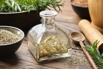 Wall Mural - bottle of dry herbs for making healing infusion or tincture. bowls of medicinal plants and wooden mo