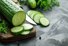 Fresh Cucumber Sliced With A Knife, On A Wooden Board