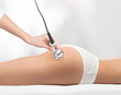 © Dimid - The doctor does the Rf lifting procedure on the legs, buttocks and hips of a woman in a beauty parlor. Treatment of overweight and flabby skin.