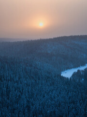 Wall Mural - Sunrise over a snow-covered forest.