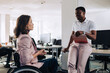 © Zamrznuti tonovi - A businesswoman with disability is discussing project with a colleague.