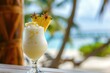Closeup photo of fresh cold alcoholic fruit pina colada cocktail drink glass with cream and pineapple with blurry tropical beach bar in the background