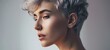 © Fat Bee - Close-up profile portrait of a young Caucasian woman with short hair dyed grey. Attractive female model with trendy hairstyle and perfect makeup. Isolated on grey background.