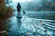 girl swims on a rainy lake on a sup board