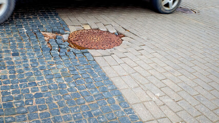 collapse of tile stones on the road. Hatches on the road.